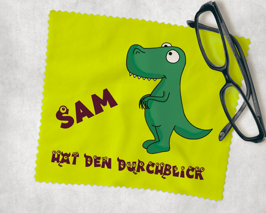 Brillenputztuch in hellgrün it einem Comic Dino, dem Text hat den Durchblick und eurem Wunschnamen