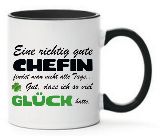 Schwarze Tasse mit Spruch Eine richtig gute Chefin findet man nicht alle Tage... Gut, dass ich so viel Glück hatte. Mit Kleeblatt und Glück in grün geschrieben